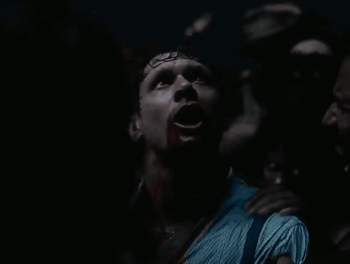 Man with Blood on Face Surrounded by Crowd