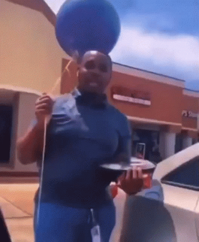 Man with Blue Balloon on Head at Store