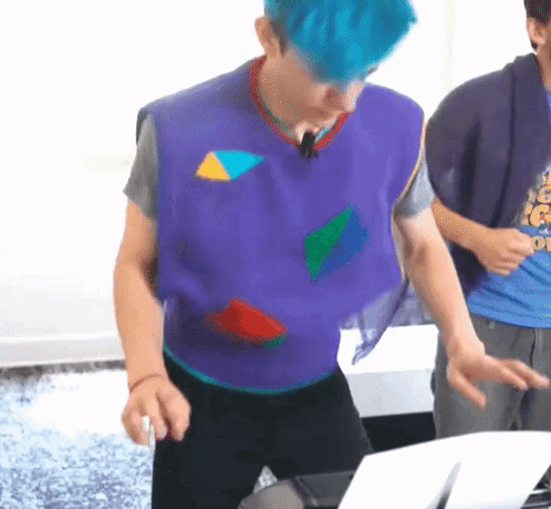 Man With Blue Hair Wearing Purple Vest With Geometric Shapes