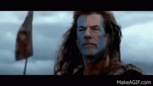 Man With Blue Paint On Face And Flag In Field GIF
