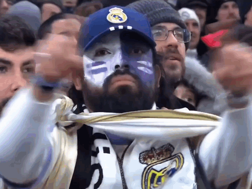 Man With Blue Paint on Face Wearing Real Madrid Cap