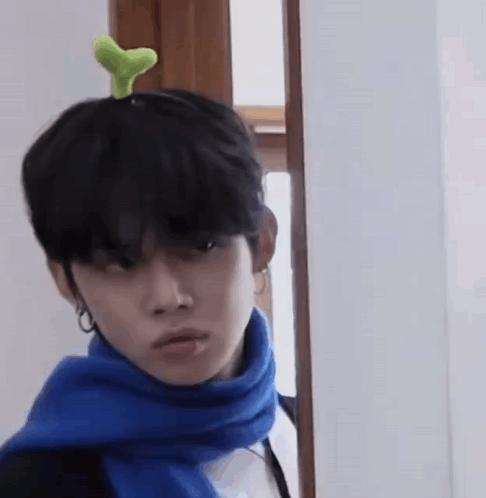 Man With Blue Scarf and Green Plant on Head