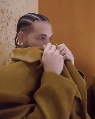 Man With Braids And Earrings Covering Face With Blanket GIF