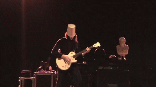 Man With Bucket on Head Playing Guitar on Stage