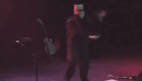 Man With Bucket On Head Playing Guitar On Stage GIF
