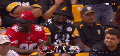 Man With Chain Watching Football in Stadium