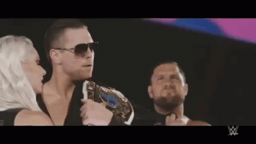 Man with Championship Belt Next to Woman and Bearded Man