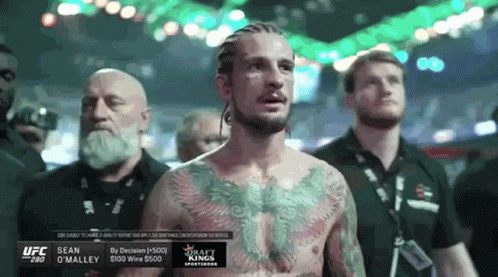 Man With Chest Tattoo And Other Men In Boxing Ring GIF