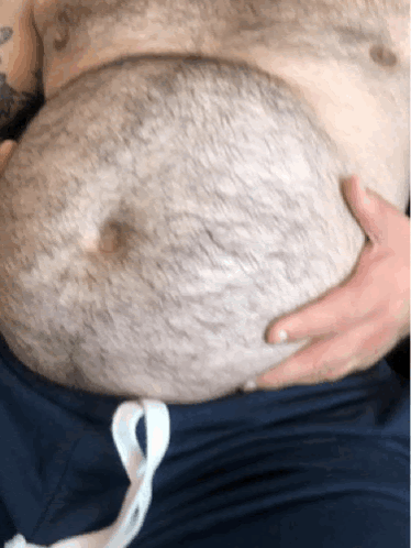 Man With Chest Tattoo Holding Stomach