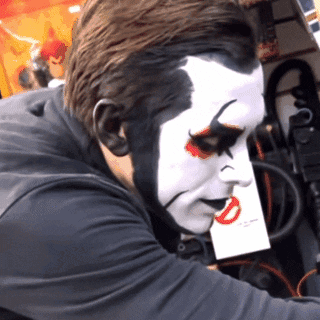 Man with Clown Face Holding Paper