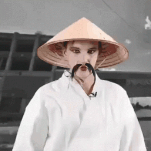 Man With Conical Hat And Mustache In White Robe GIF
