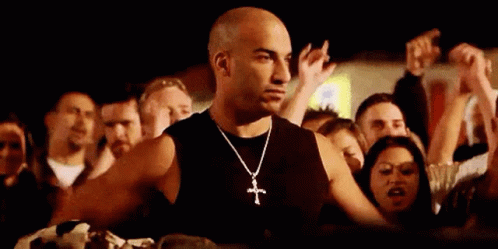 Man With Cross Necklace Standing Before Crowd