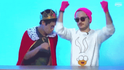 Man With Crown Beside Man in Cartoon Sweater