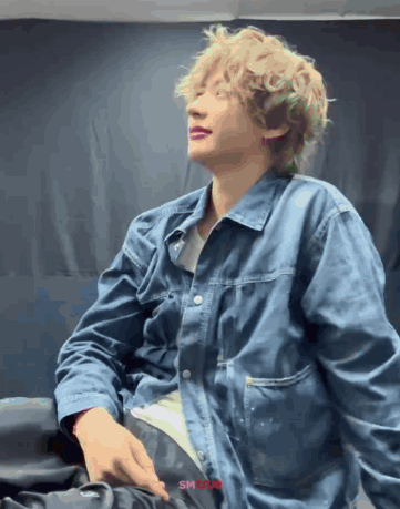 Man With Curly Blonde Hair in Blue Jacket