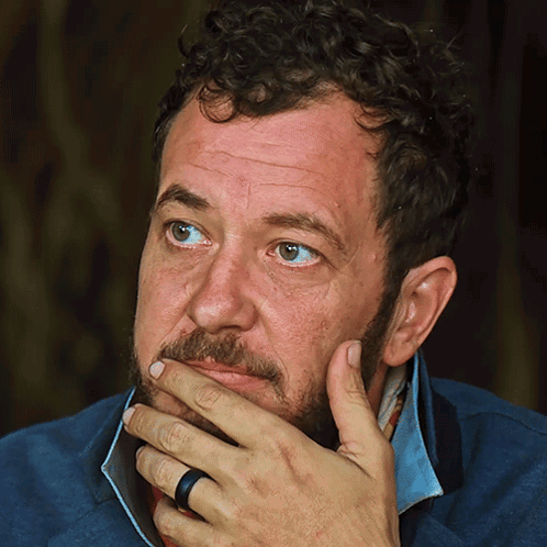 Man With Curly Hair and Beard Hand on Chin