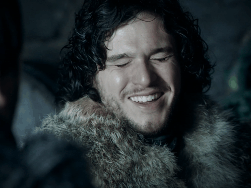 Man With Curly Hair and Beard in Fur Coat Smiles