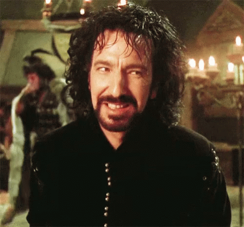 Man With Curly Hair and Beard Smiling in Front of Candles