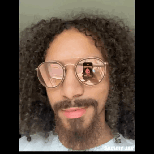 Man with Curly Hair and Beard Taking Photo