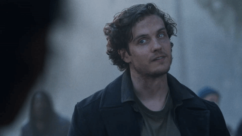 Man with Curly Hair and Blue Eyes in Black Coat