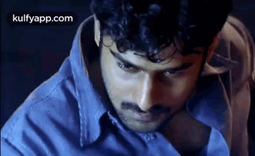 Man with Curly Hair and Mustache in Blue Shirt