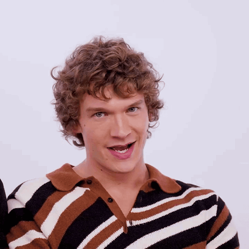 Man with Curly Hair and Striped Shirt Smiling