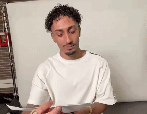 Man With Curly Hair Holding Paper GIF