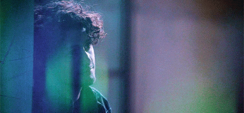 Man With Curly Hair in Front of Blue Wall