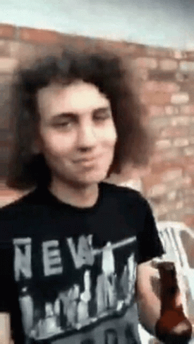 Man with Curly Hair in New York Shirt Holding Beer