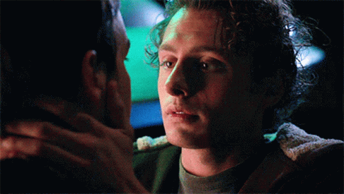 Man With Curly Hair Looking At Another Man GIF