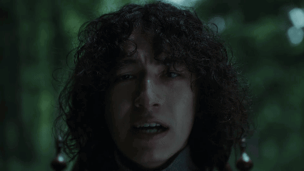 Man With Curly Hair Making Funny Face in Dark