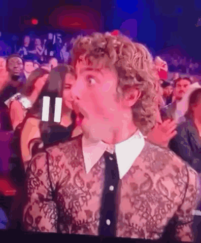 Man With Curly Hair Surprised In Crowd GIF
