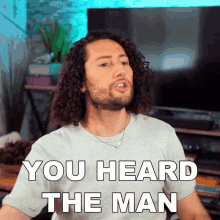 Man with Curly Hair Wearing You Heard The Man T-Shirt