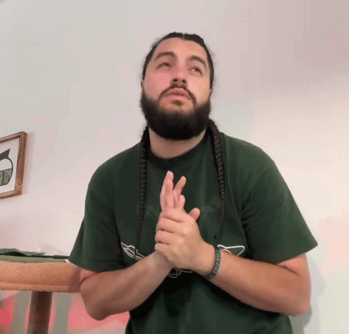 Man with Dreadlocks and Beard in Green Shirt Saying No