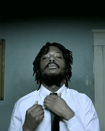 Man With Dreadlocks and Beard Tying Tie