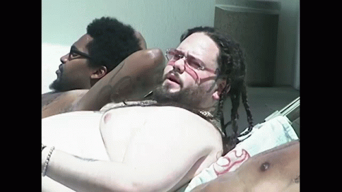Man With Dreadlocks and Glasses Laying on Beach