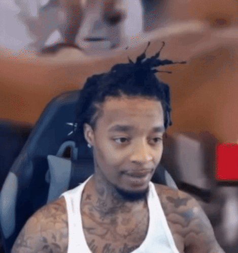 Man With Dreadlocks and Tattoos Looking at Camera