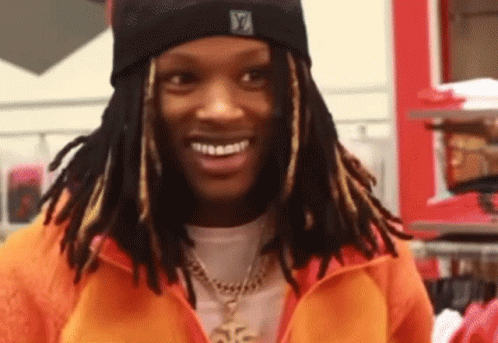Man With Dreadlocks in Orange Jacket and Black Beanie