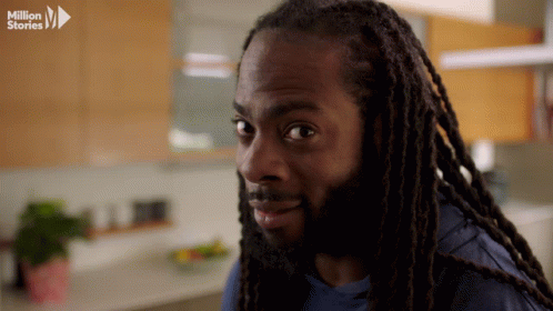 Man With Dreadlocks Looking at Camera With Million Stories Logo