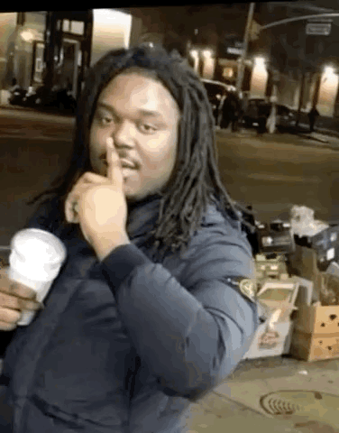 Man with Dreadlocks Making Shhh Gesture