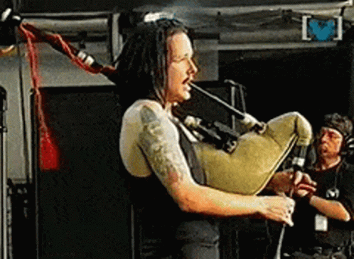Man With Dreadlocks Playing Bagpipe On Stage