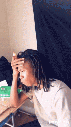 Man With Dreadlocks Sitting At Desk Hand On Head GIF