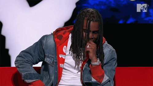 Man With Dreadlocks Sitting on Red Couch MTV Background