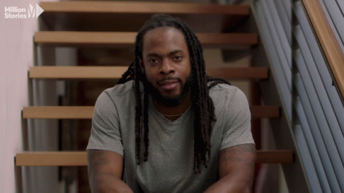 Man With Dreadlocks Sitting on Stairs Million Stories Logo