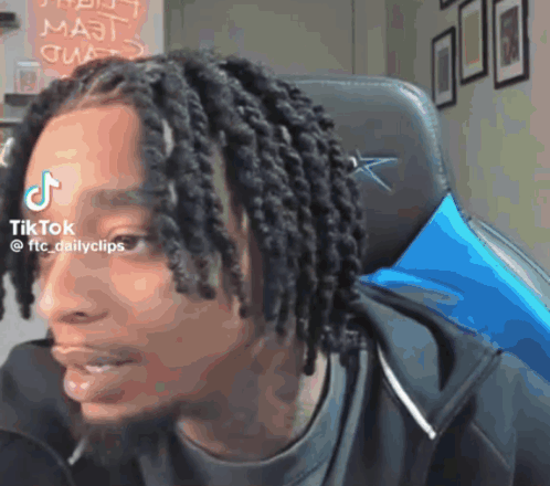 Man With Dreadlocks Sitting With TikTok Sticker on Forehead