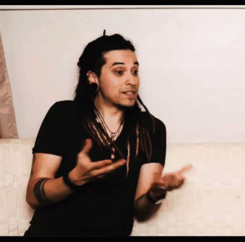 Man With Dreadlocks Talking On Couch GIF