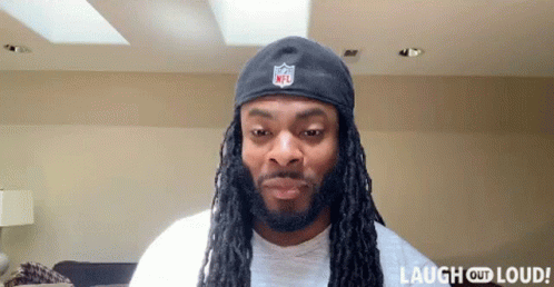 Man With Dreadlocks Wearing NFL Hat Laughing Out Loud