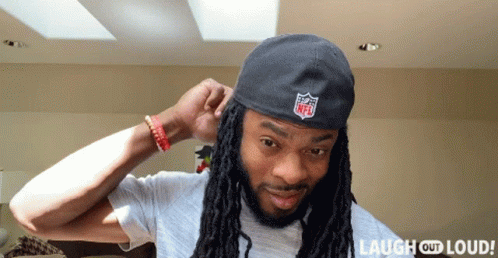 Man With Dreadlocks Wearing NFL Logo Hat