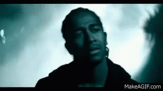 Man With Ear Piercing Looking At Camera In Dark Room GIF