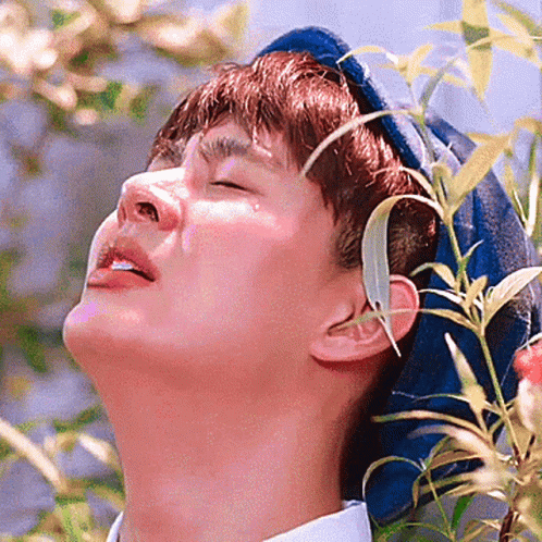 Man With Eyes Closed and Plant in Ear