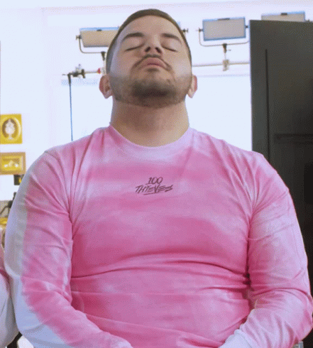 Man With Eyes Closed Wearing Pink 100 Thieves Shirt
